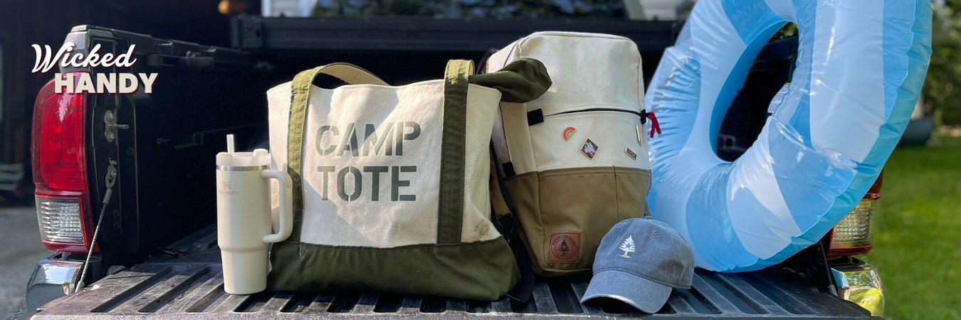 Truck bed with 'CAMP TOTE' bag, boots, and inflatable pool toy with 'Wicked Handy' branding.